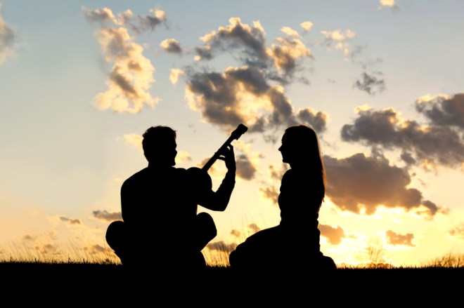 Silhouette of Couple Playing Guitar at Sunset