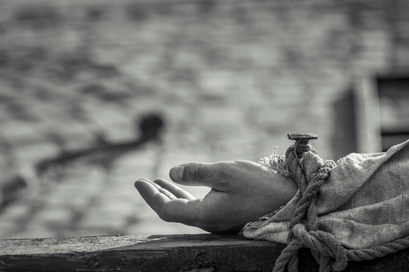 Nailed hand on wooden cross